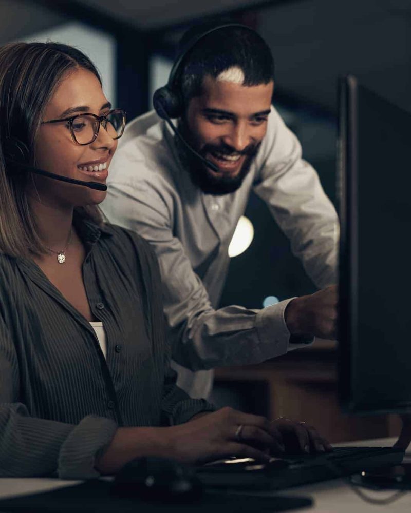 shot-of-two-call-centre-agents-working-together-in-an-office-at-night.jpg